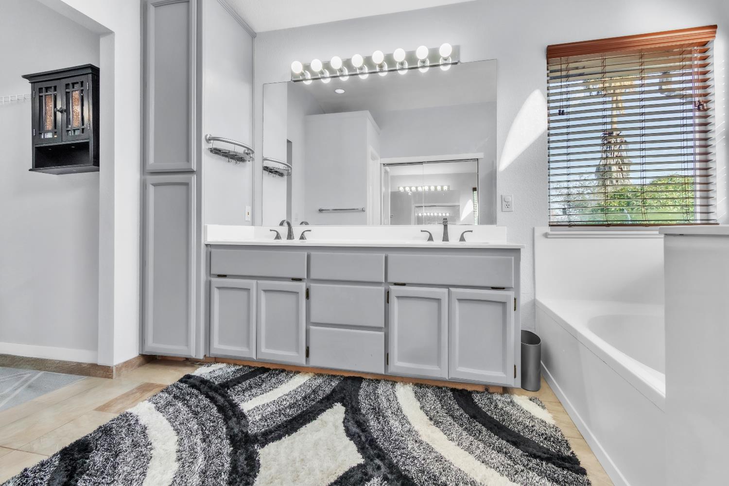 8148 Orchid Tree Way Antelope, CA 95843 - Photo 27 of 33 a spacious bathroom with a double vanity sink a mirror and a bathtub