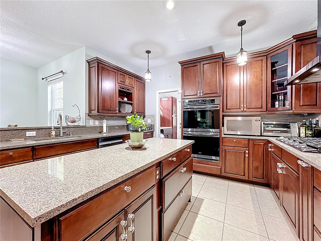 4295 Rambler Avenue St. Cloud, FL 34772 - Photo 20 of 54 a kitchen with stainless steel appliances granite countertop a sink and stove