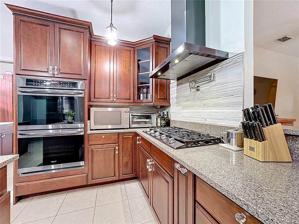 4295 Rambler Avenue St. Cloud, FL 34772 - Photo 21 of 54 a kitchen with stainless steel appliances granite countertop a stove and a microwave