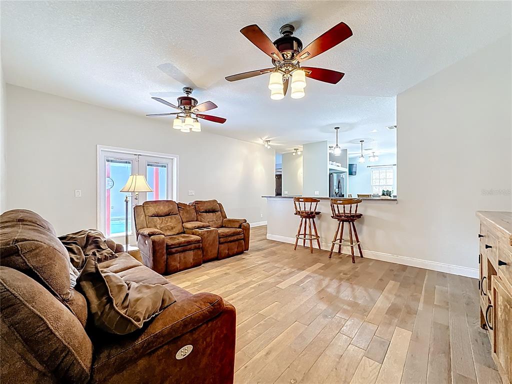 4295 Rambler Avenue St. Cloud, FL 34772 - Photo 24 of 54 a living room with furniture and a chandelier