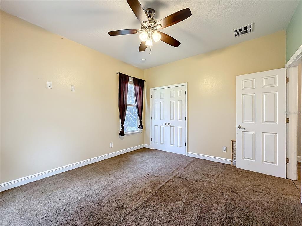 4295 Rambler Avenue St. Cloud, FL 34772 - Photo 26 of 54 an empty room with windows and fan