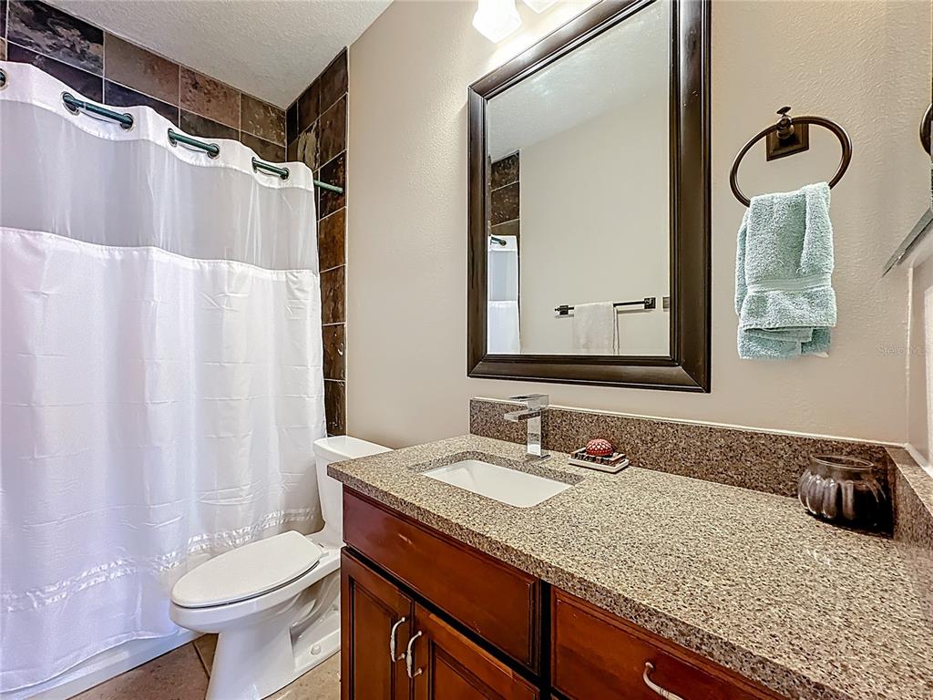 4295 Rambler Avenue St. Cloud, FL 34772 - Photo 29 of 54 a bathroom with a granite countertop sink toilet and shower