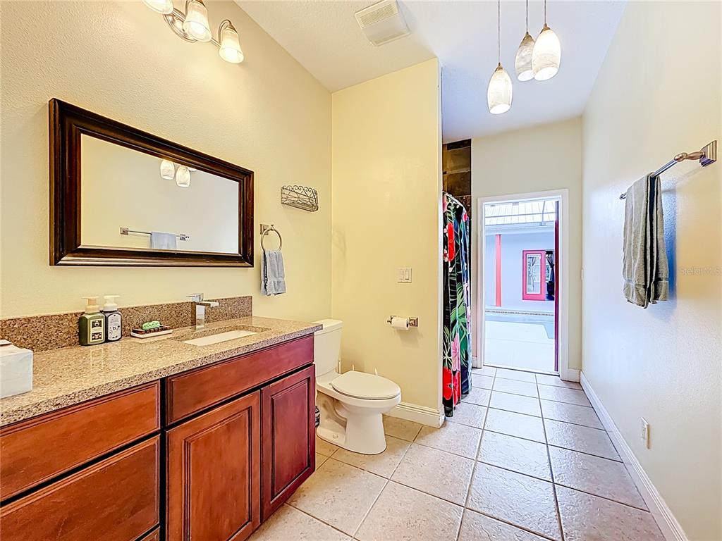 4295 Rambler Avenue St. Cloud, FL 34772 - Photo 33 of 54 a bathroom with a toilet sink vanity and mirror