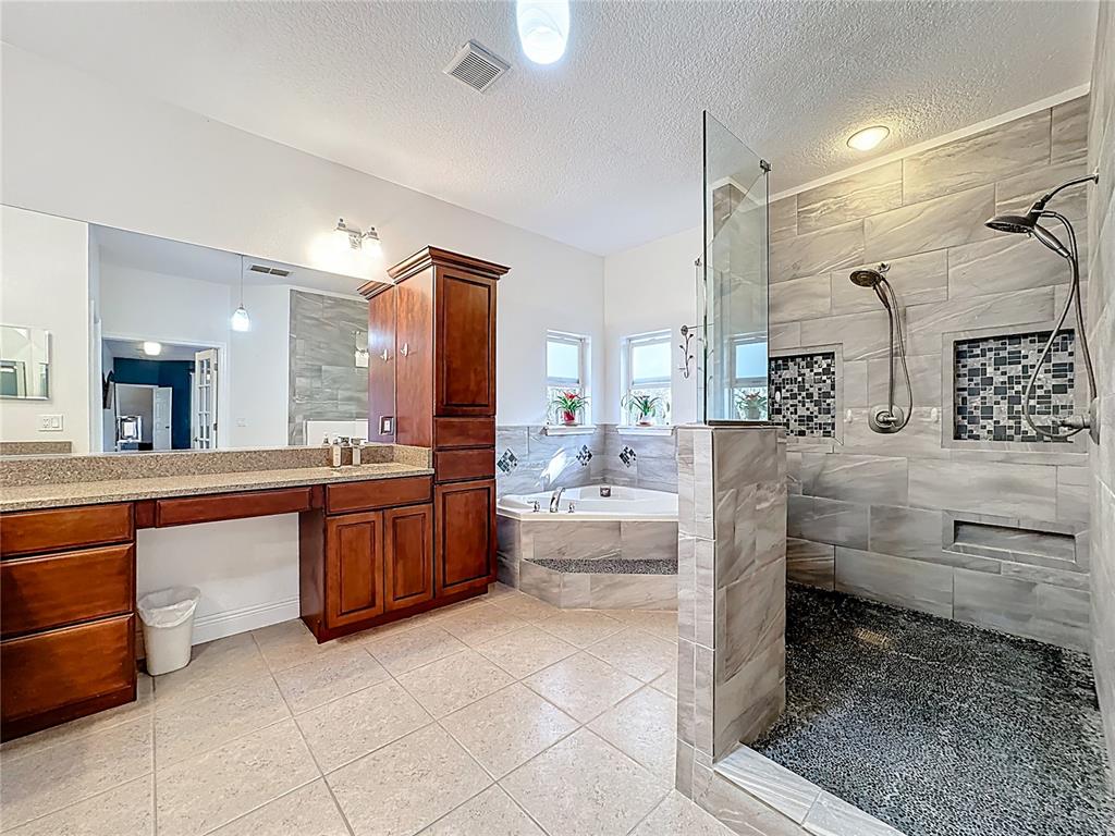 4295 Rambler Avenue St. Cloud, FL 34772 - Photo 37 of 54 a bathroom with a granite countertop sink mirror and bathtub