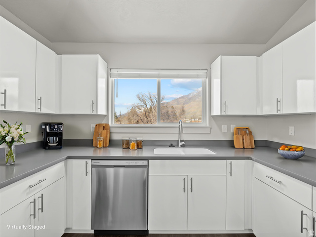 64 West 600 South, Unit C301 Springville, UT 84663 - Photo 16 of 40 Modern kitchen featuring extensive white cabinetry with stainless steel pulls, light gray countertops, and a stainless steel dishwasher