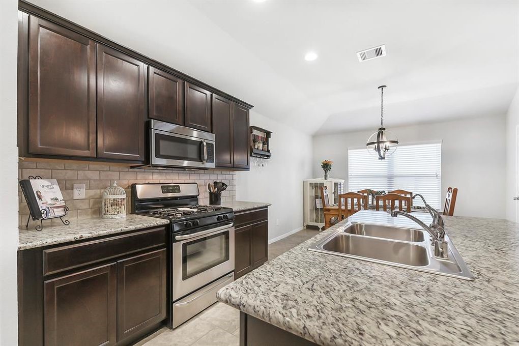 3010 Dripping Springs Court Katy, TX 77494 - Photo 4 of 22 a kitchen with granite countertop stainless steel appliances a stove sink microwave and cabinets