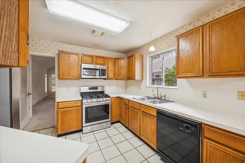 a kitchen with stainless steel appliances granite countertop a sink stove and cabinets