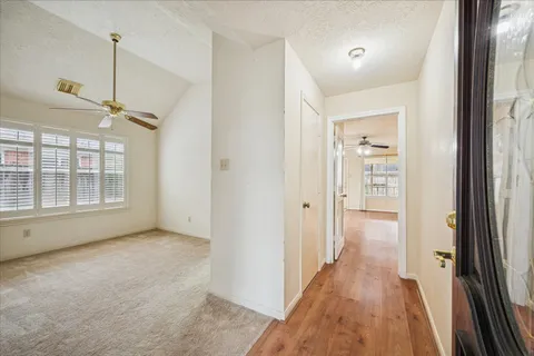 an empty room with wooden floor and windows