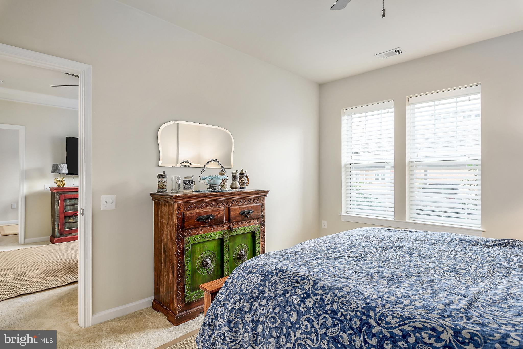 20650 Hope Spring Terrace, Unit 103 Ashburn, VA 20147 - Photo 13 of 30 a bedroom with a bed and a mirror on dresser
