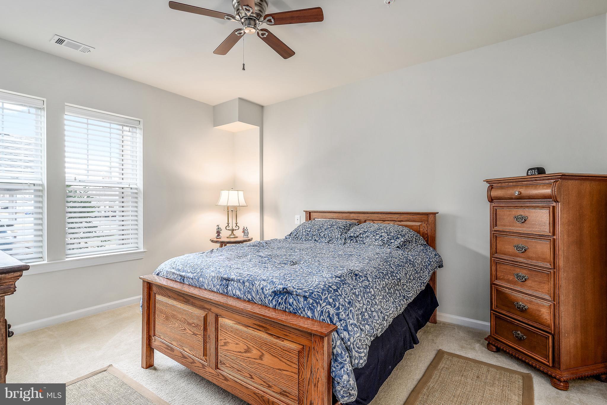 20650 Hope Spring Terrace, Unit 103 Ashburn, VA 20147 - Photo 14 of 30 a bedroom with a bed and a dresser