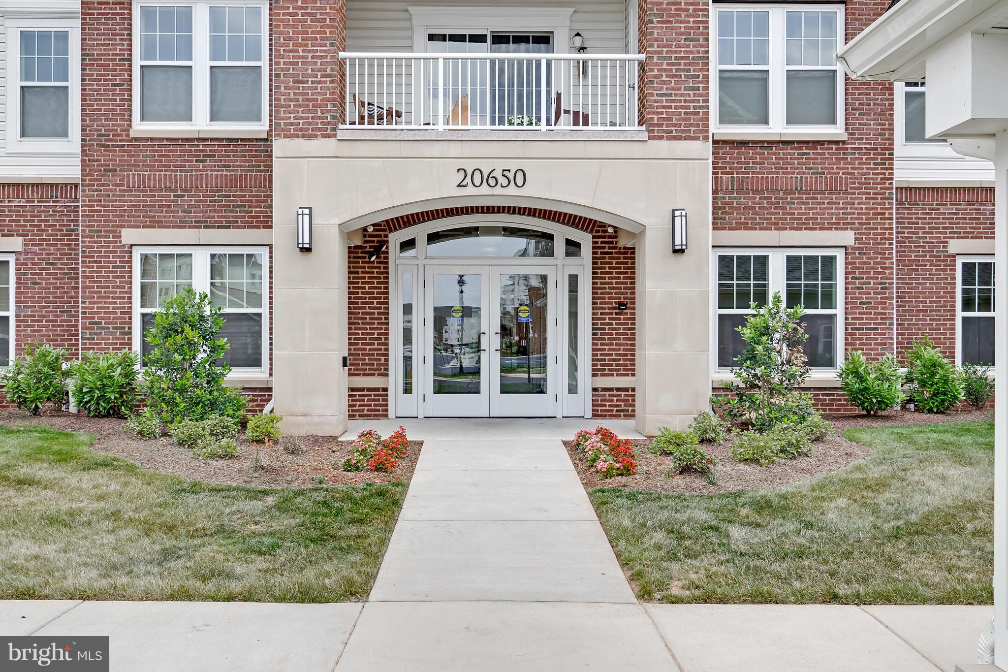 20650 Hope Spring Terrace, Unit 103 Ashburn, VA 20147 - Photo 3 of 30 a front view of a house with garden