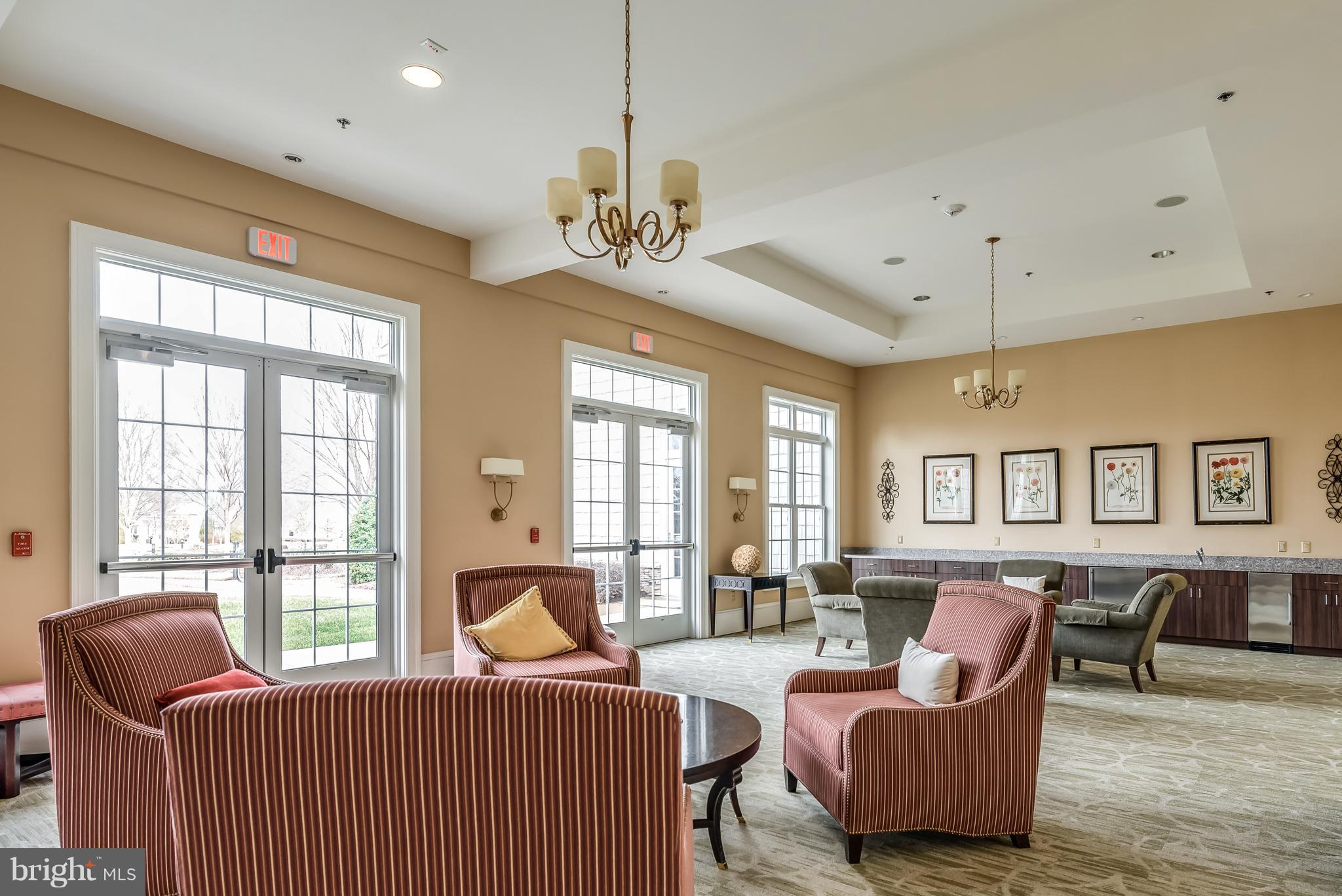 20650 Hope Spring Terrace, Unit 103 Ashburn, VA 20147 - Photo 29 of 30 a living room with furniture two large windows and a chandelier