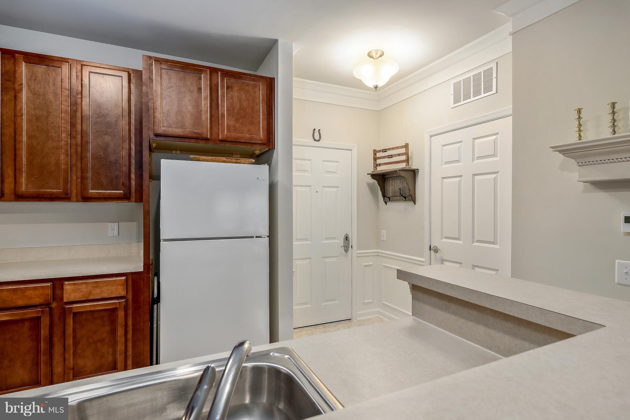 20650 Hope Spring Terrace, Unit 103 Ashburn, VA 20147 - Photo 6 of 30 a kitchen with stainless steel appliances granite countertop a refrigerator and a sink