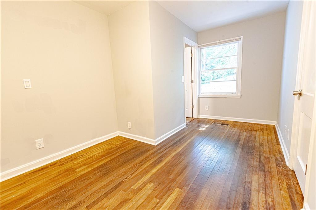145 Holly Road Northwest Atlanta, GA 30314 - Photo 18 of 28 an empty room with wooden floor and windows