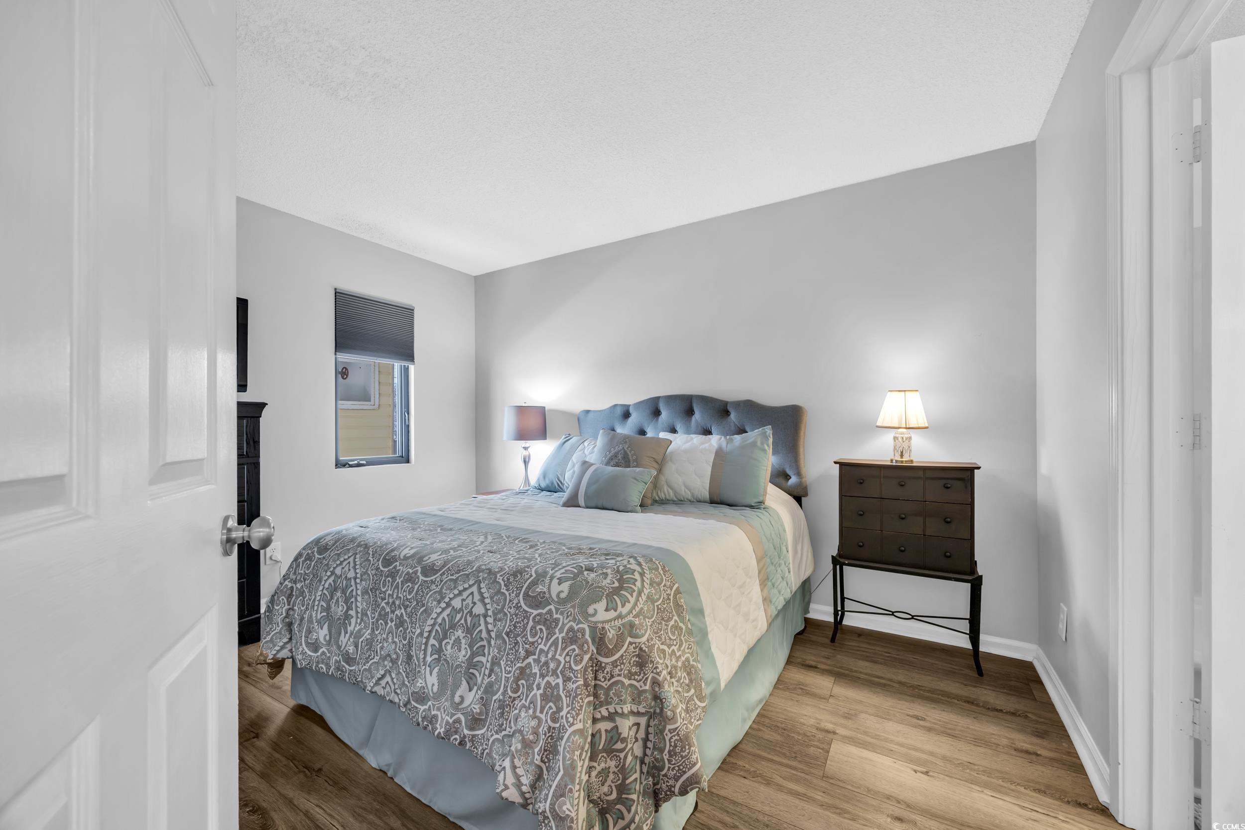 1100 Possum Trot Road, Unit C202 North Myrtle Beach, SC 29582 - Photo 8 of 34 Bedroom with a textured ceiling, wood finished flo