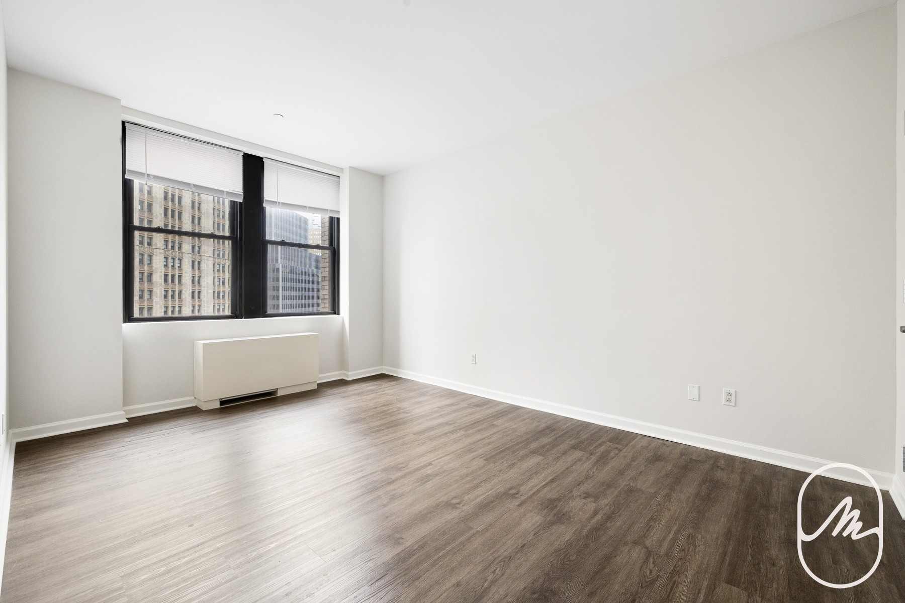 15 Park Row, Unit 3M Manhattan, NY 10038 - Photo 3 of 10 an empty room with wooden floor and windows