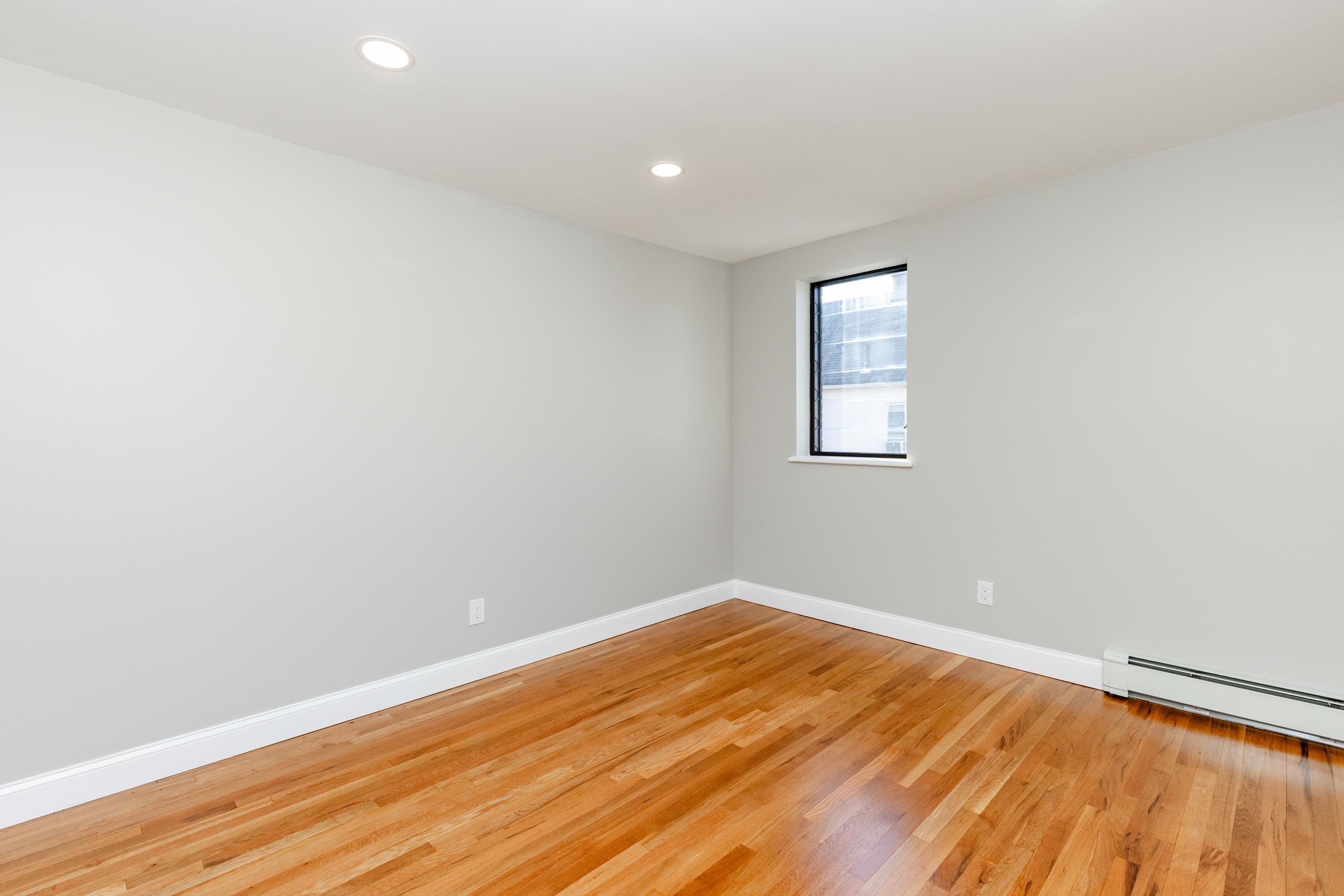 100 Lakeview Avenue, Unit 3A Clifton, NJ 07011 - Photo 11 of 13 an empty room with wooden floor and windows