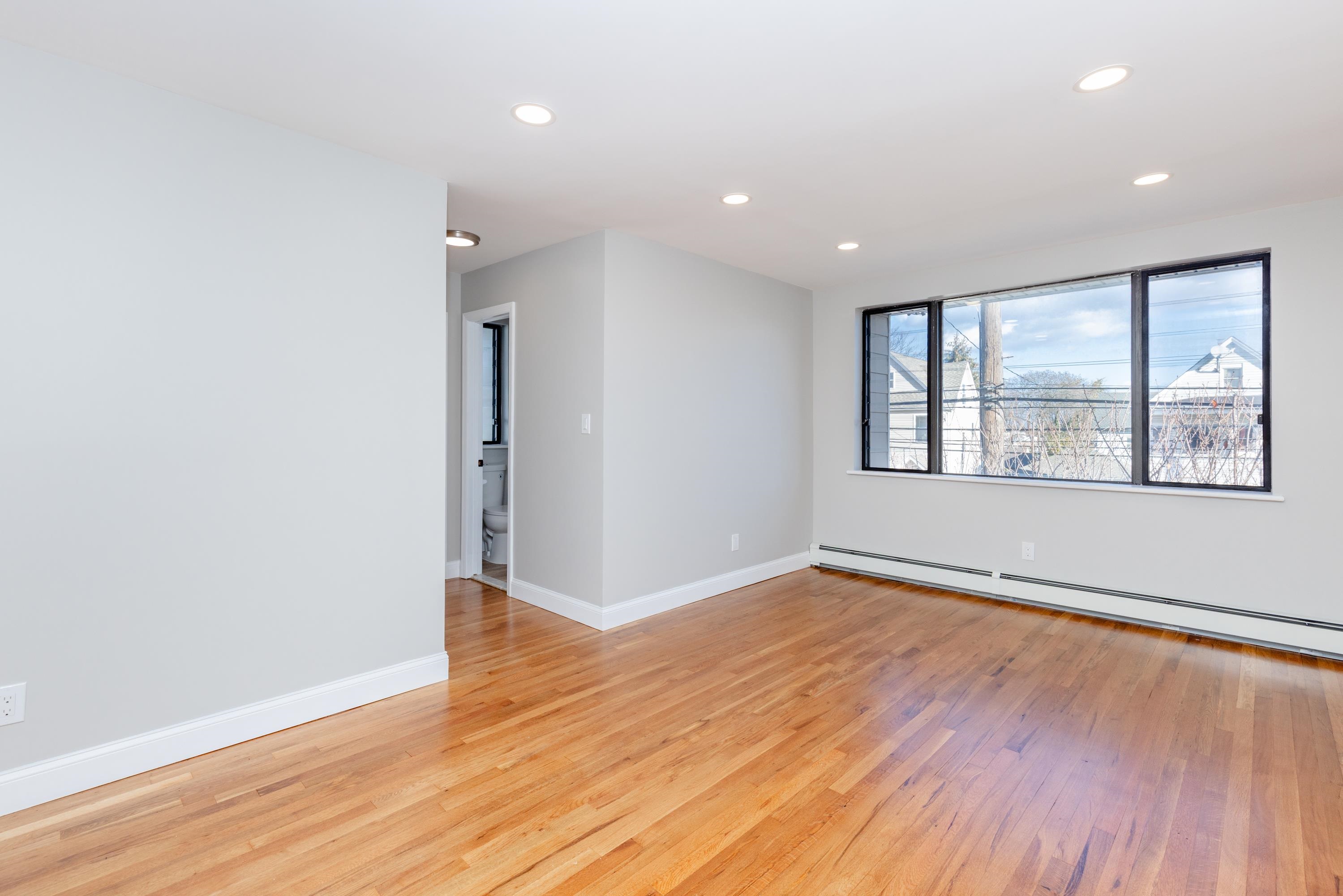 100 Lakeview Avenue, Unit 3A Clifton, NJ 07011 - Photo 6 of 13 an empty room with wooden floor and windows