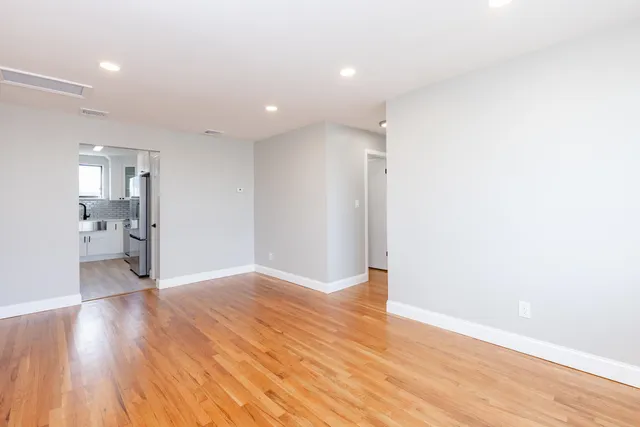 a view of an empty room with wooden floor