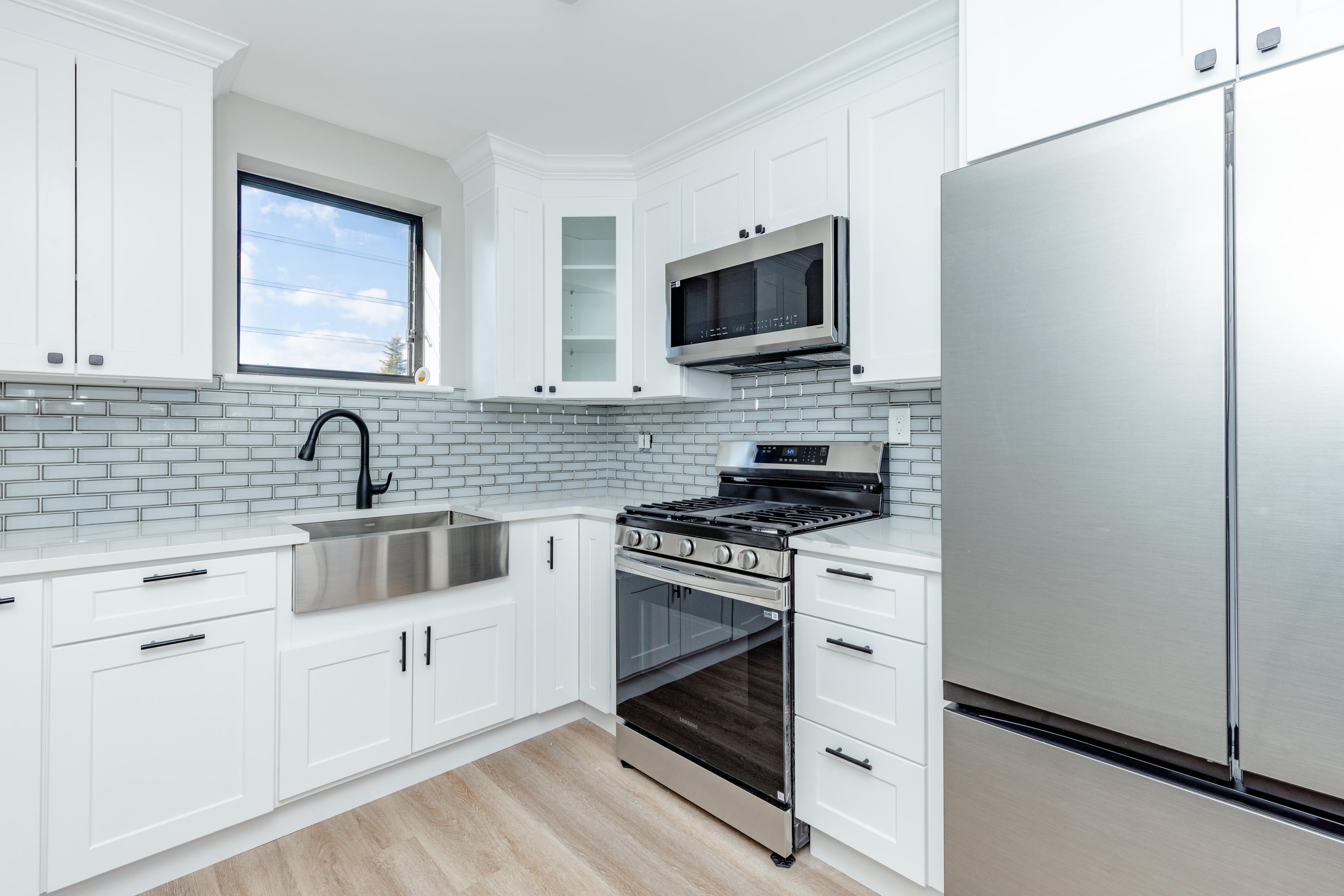 100 Lakeview Avenue, Unit 3A Clifton, NJ 07011 - Photo 10 of 13 a kitchen with white cabinets stainless steel appliances and sink