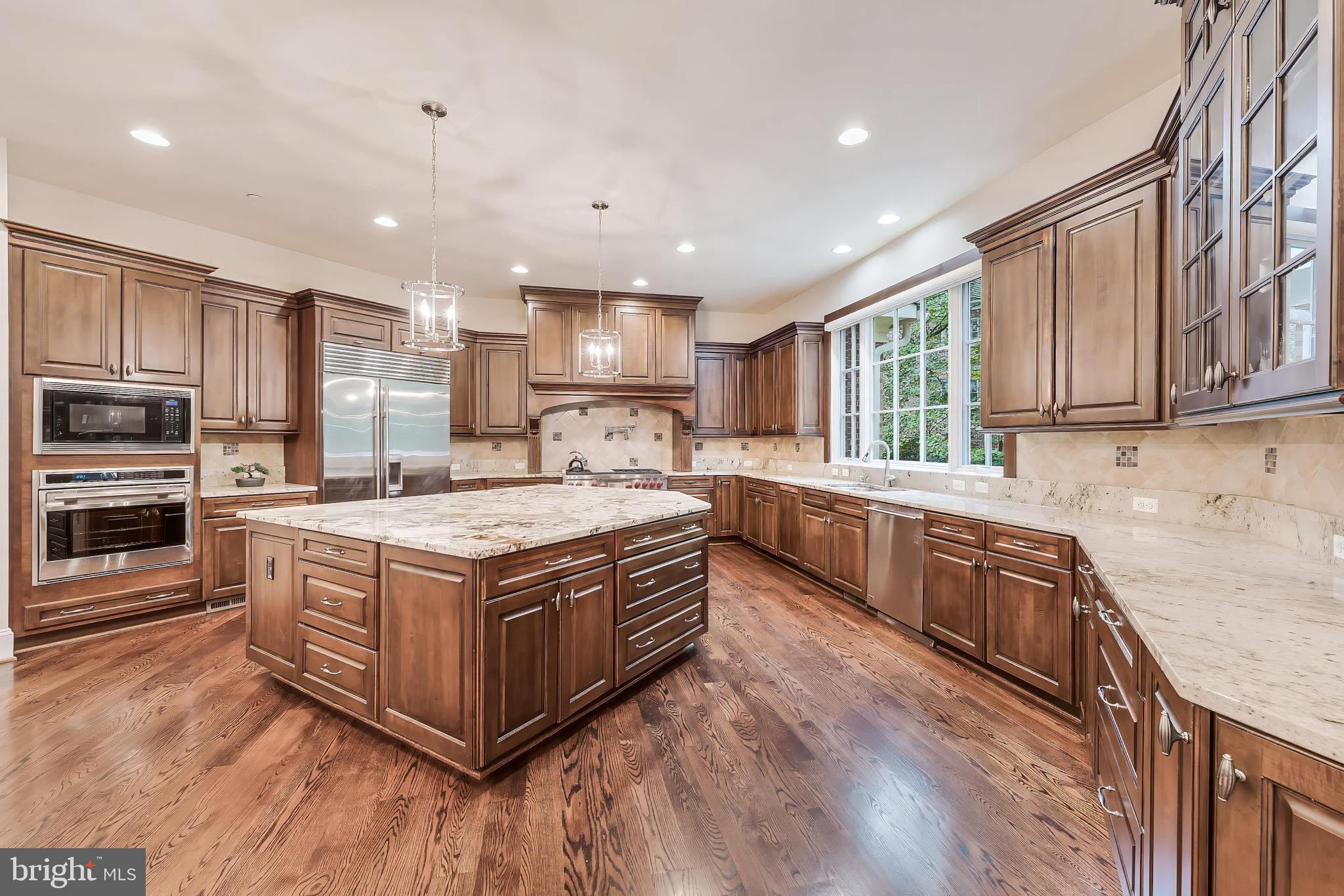 7020 Mountain Gate Drive Bethesda, MD 20817 - Photo 12 of 42 a large kitchen with stainless steel appliances granite countertop a stove a sink dishwasher a refrigerator white cabinets and wooden floor