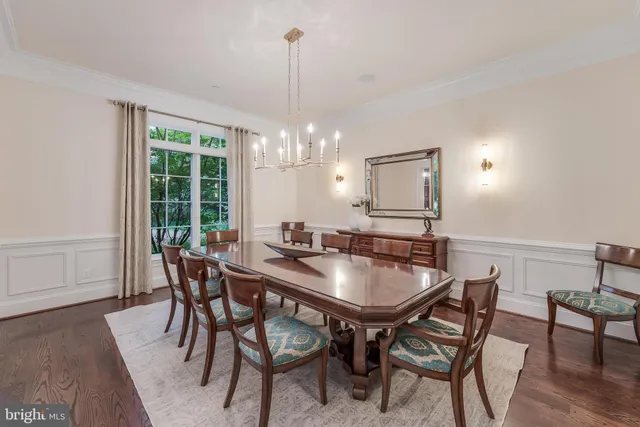 a dining room with furniture a chandelier and wooden floor