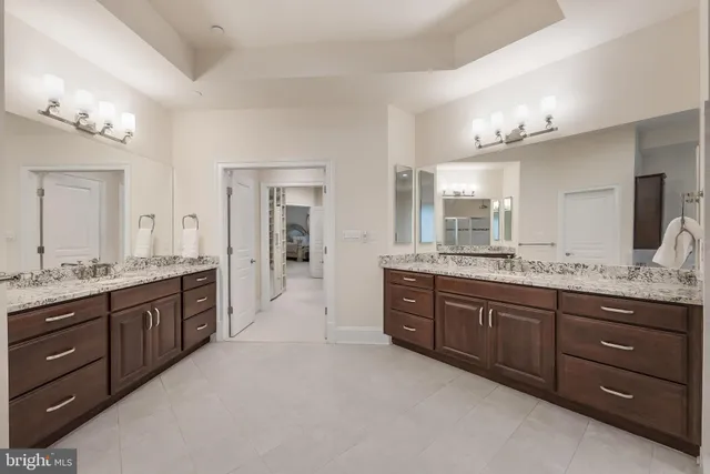 a large bathroom with a granite countertop double vanity and a large mirror