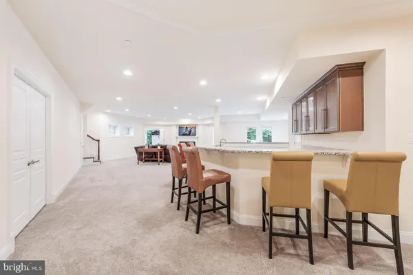 a dining hall with stainless steel appliances a dining table chairs and kitchen view