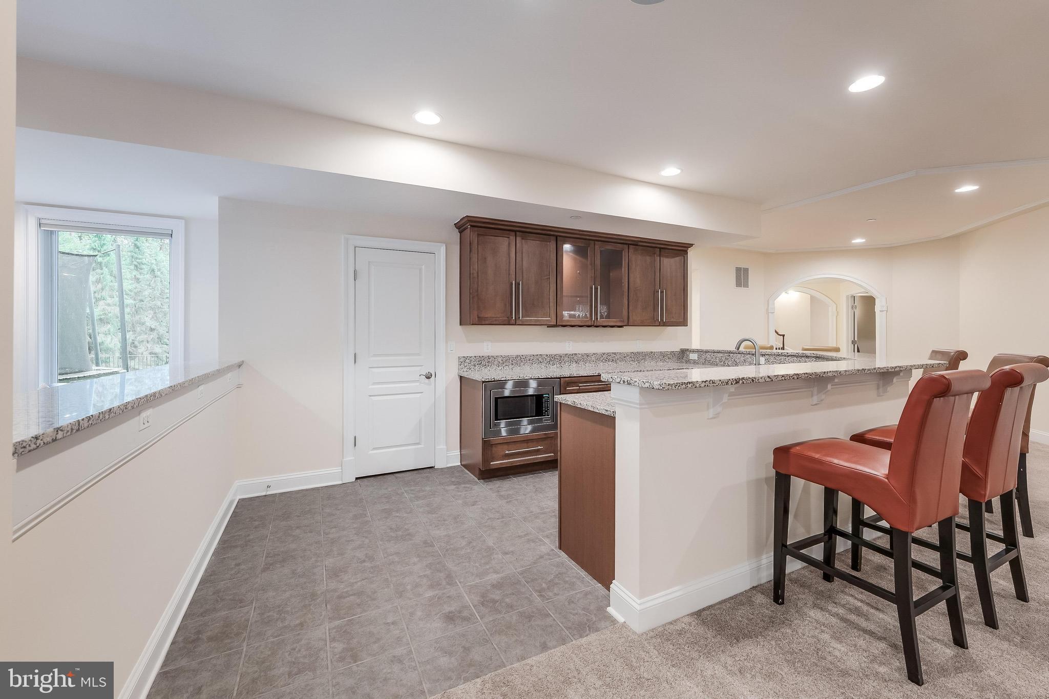 7020 Mountain Gate Drive Bethesda, MD 20817 - Photo 34 of 42 a kitchen with stainless steel appliances granite countertop a stove top oven a sink dishwasher a dining table and chairs with wooden floor