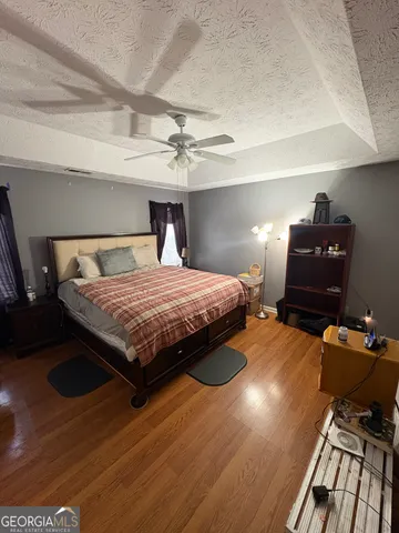a bedroom with a bed and wooden floor