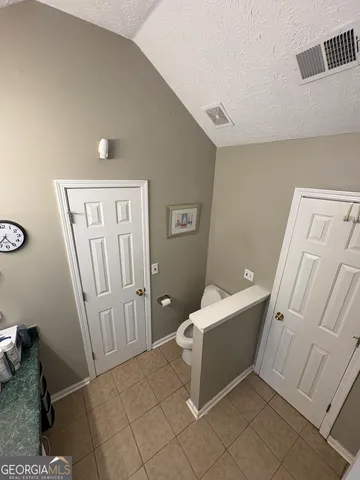 a living room with furniture and a refrigerator