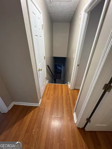 a view of a hallway with wooden floor and staircase