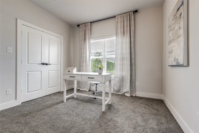 a view of a workspace with furniture and a window