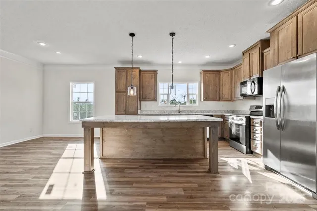 a kitchen with stainless steel appliances granite countertop a refrigerator a stove a sink and a refrigerator