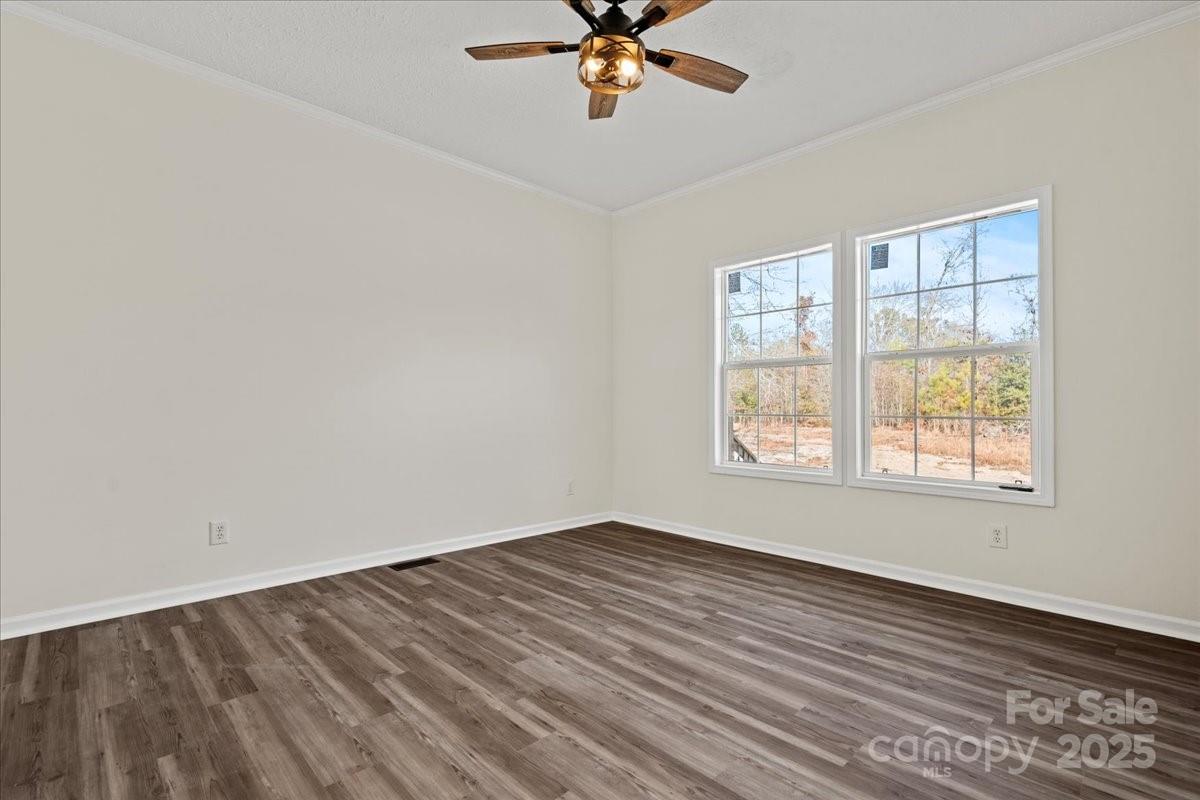 5257 Raleys Mill Road Bethune, SC 29009 - Photo 32 of 48 an empty room with wooden floor fan and windows