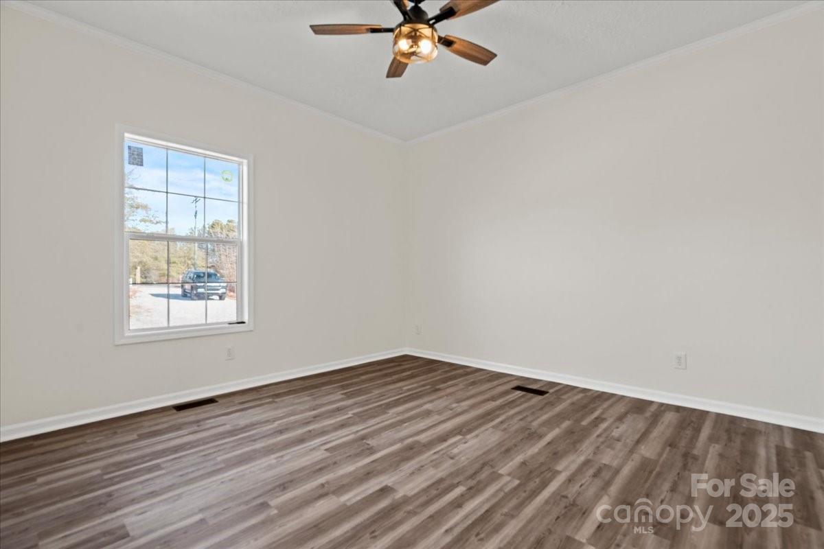 5257 Raleys Mill Road Bethune, SC 29009 - Photo 36 of 48 an empty room with wooden floor fan and windows