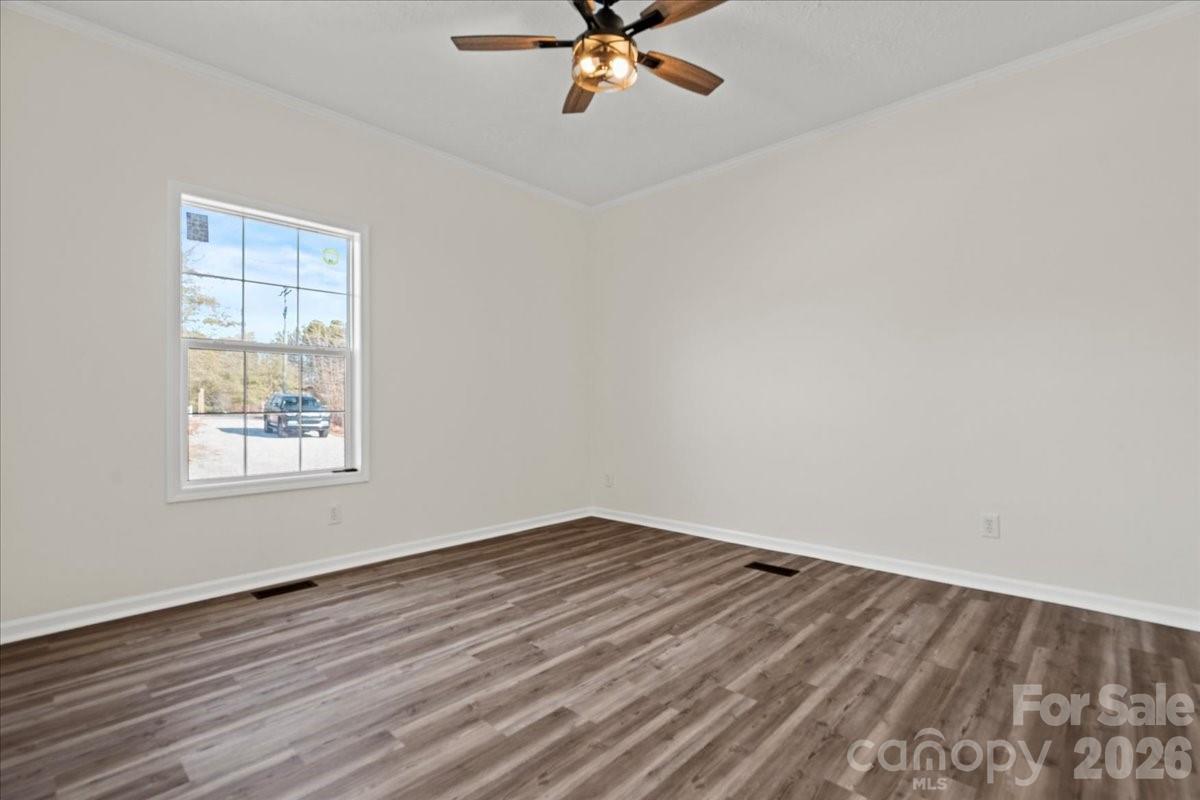 5257 Raleys Mill Road Bethune, SC 29009 - Photo 37 of 48 an empty room with wooden floor fan and windows