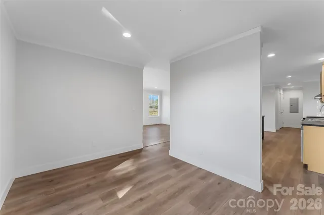 a view of a big room with wooden floor and windows