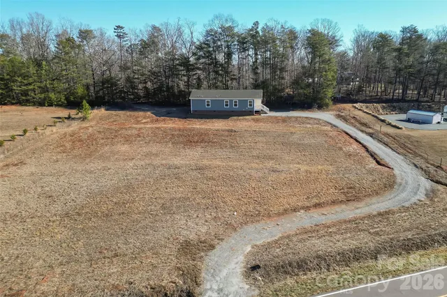 a view of a dry yard with trees