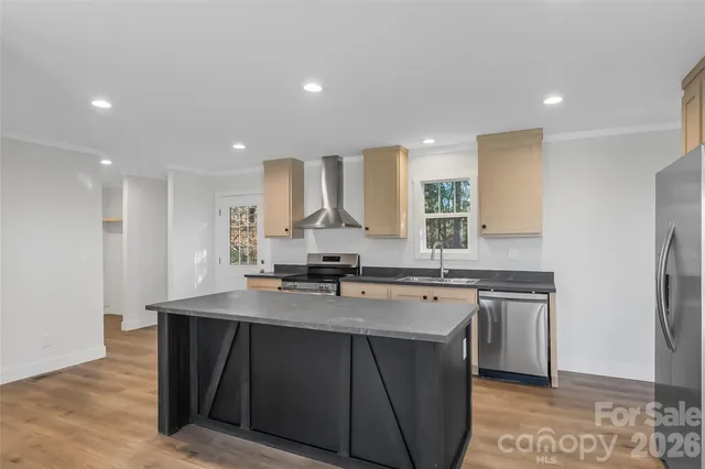 a kitchen with stainless steel appliances granite countertop a sink a stove a refrigerator and a oven