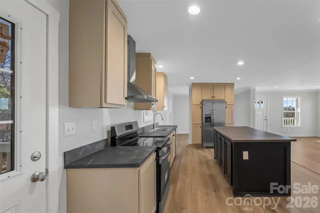 a kitchen with stainless steel appliances granite countertop a sink stove and refrigerator