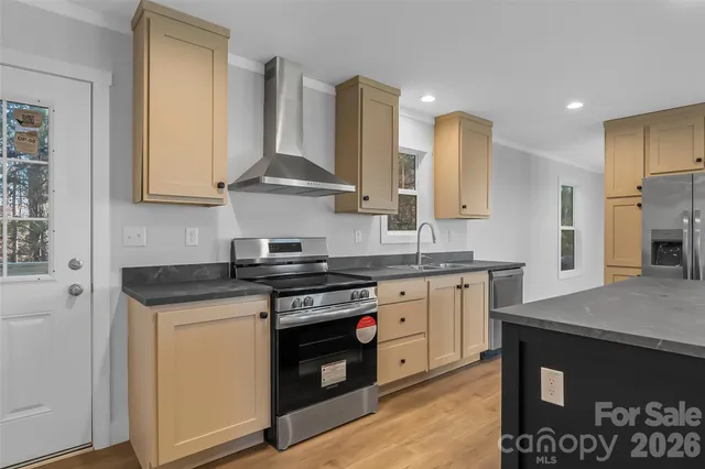a kitchen with stainless steel appliances granite countertop a stove a sink and a microwave
