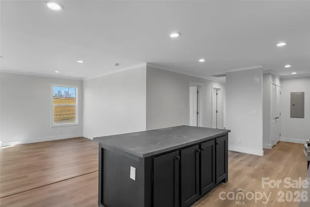 a kitchen with a stove a sink and a refrigerator with wooden floor