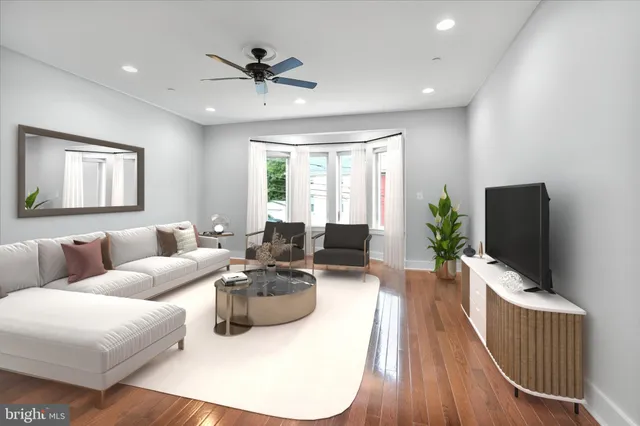 a living room with furniture a window and a flat screen tv
