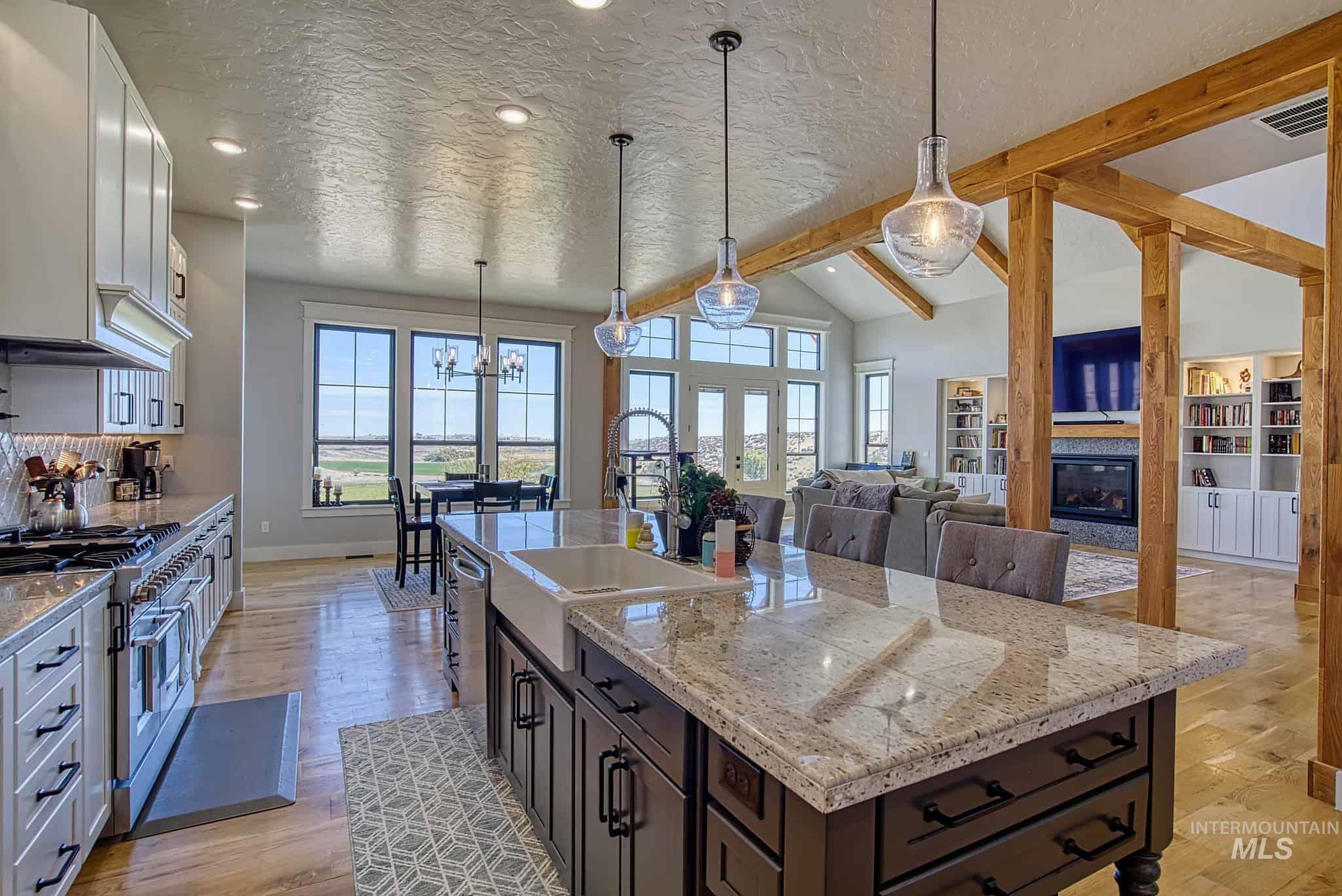 876 Coyote Gulch Road Adrian, OR 97901 - Photo 31 of 50 Open-concept kitchen featuring an expansive center island with seating, a large farmhouse sink, and pendant lighting