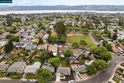 an aerial view of residential houses with outdoor space and trees