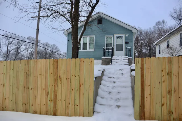 a view of a house with wooden fence