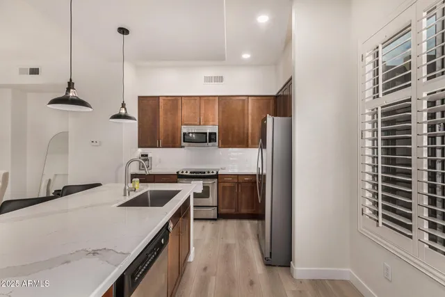 a kitchen with stainless steel appliances granite countertop a sink stove and refrigerator