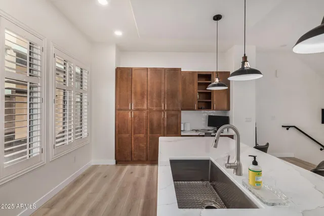 a kitchen with stainless steel appliances a stove a sink and a refrigerator with wooden floor