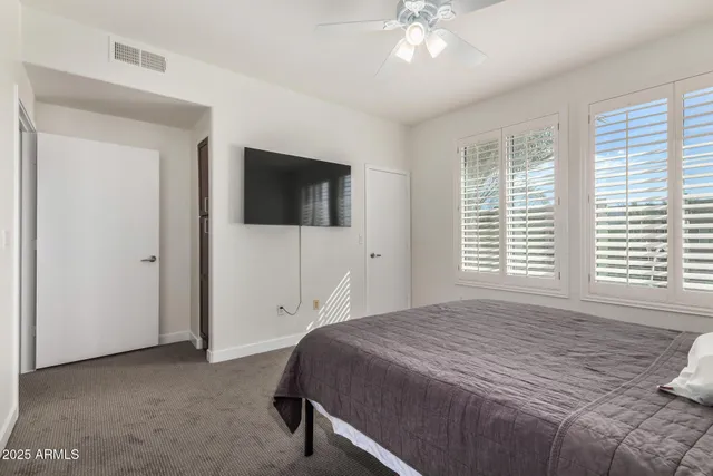 a spacious bedroom with a large bed and a flat screen tv